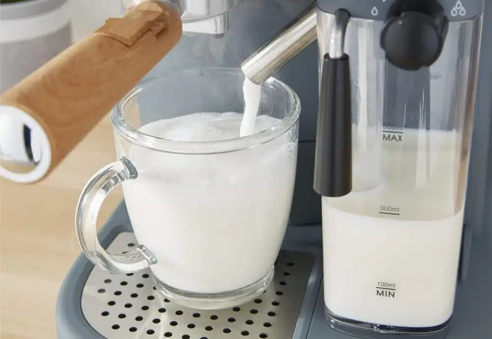 Espresso machine steaming milk into a glass mug.