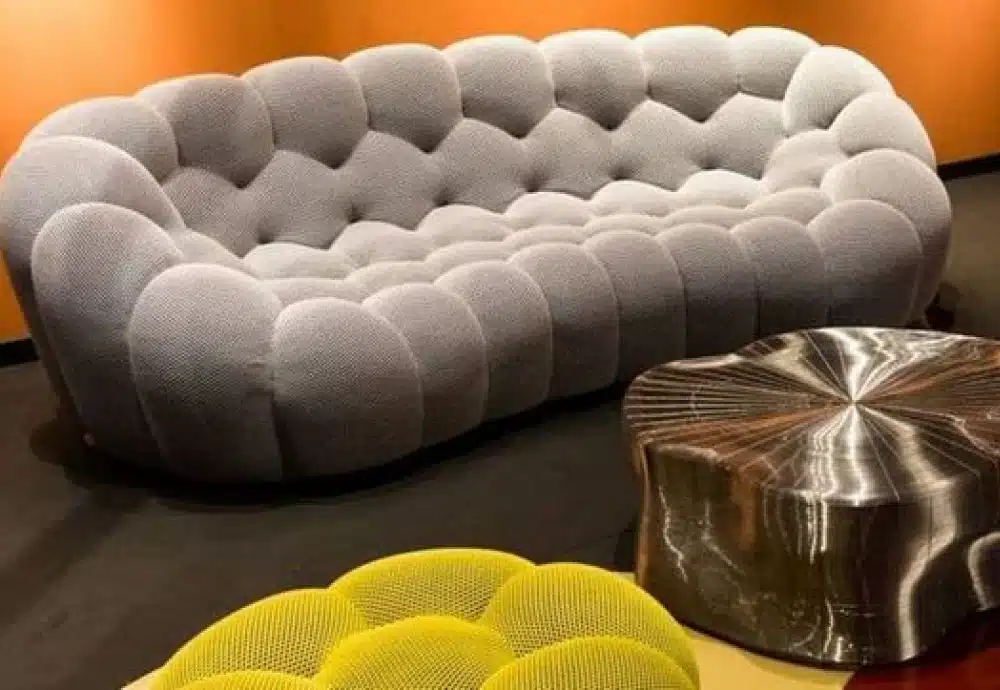 Bubble-style grey sofa with yellow cushion and wood coffee table.