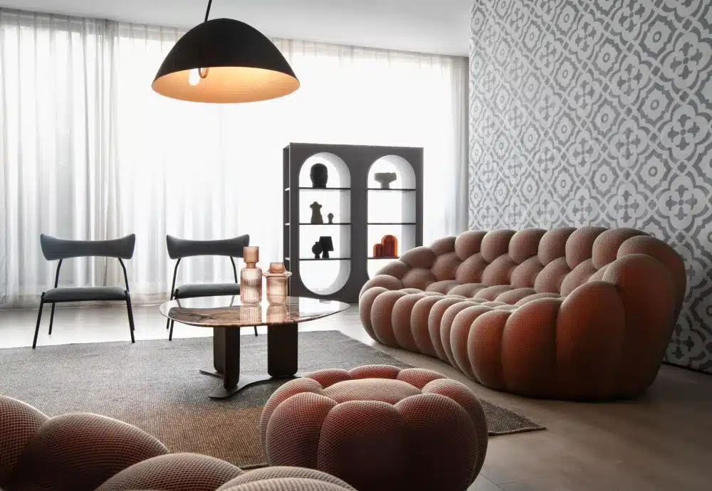 Modern living room with blush tufted sofa and minimalist decor.