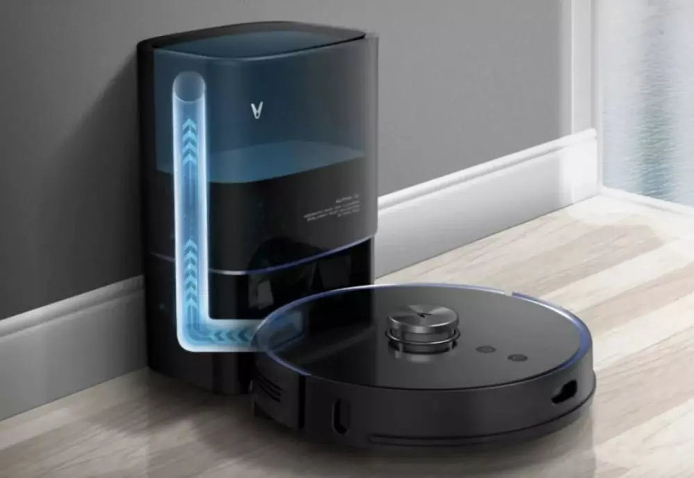 Robotic vacuum with self-emptying base on hardwood floor.