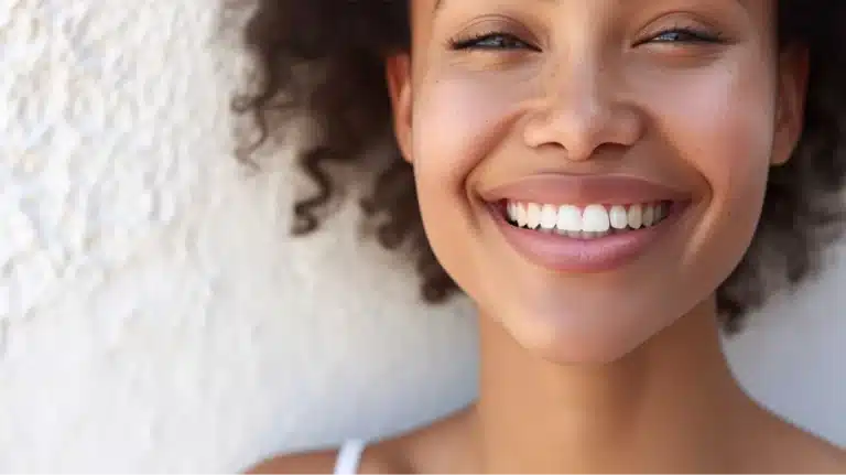 your-daily-brush-routine-just-got-an-upgrade, Close-up of a smiling woman with bright white teeth and glowing skin.