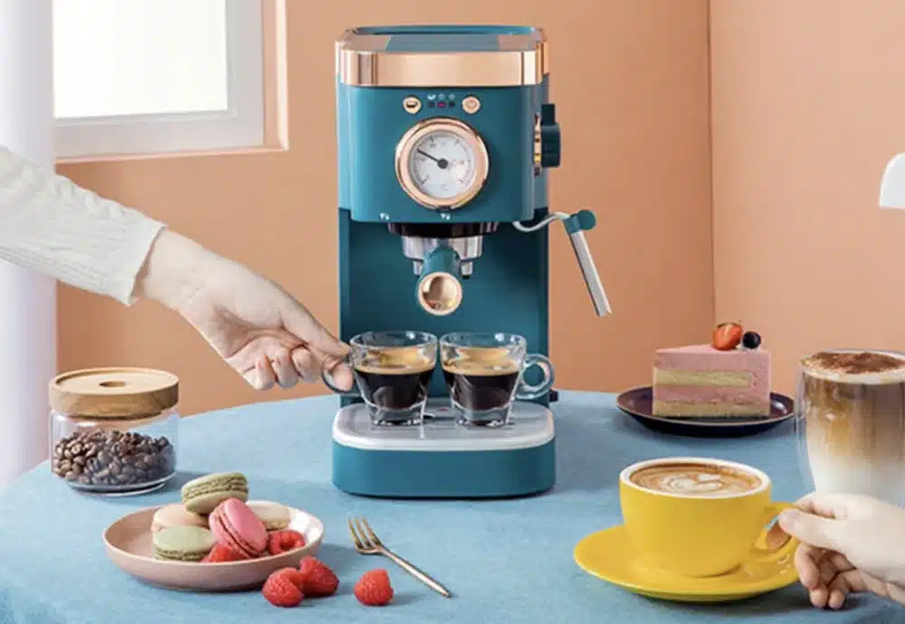 Teal espresso machine with coffee and desserts on a colorful table.