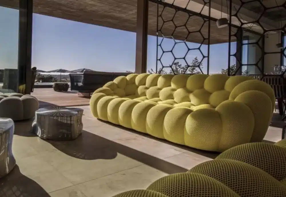 Stylish yellow tufted sofa in a modern open-air lounge.