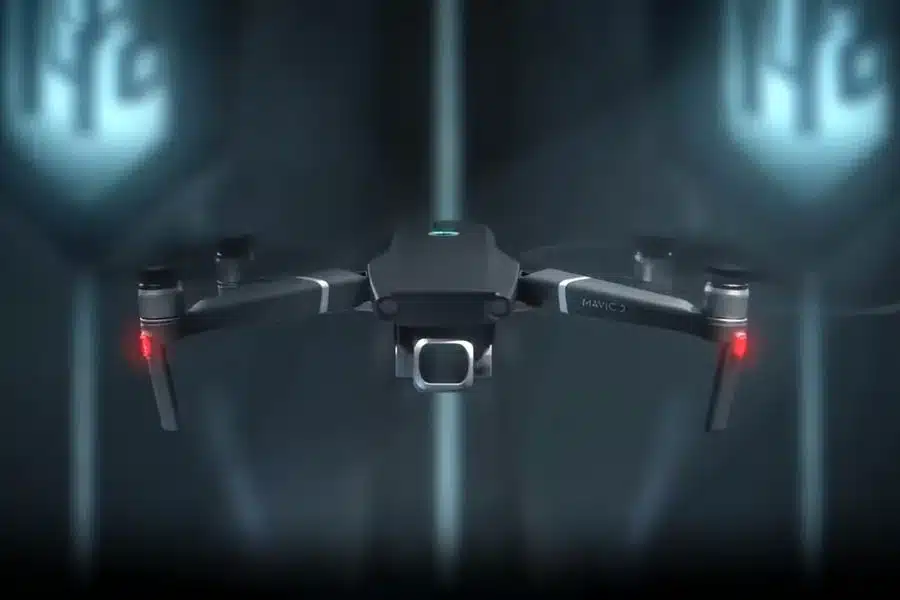 Futuristic black drone with camera, hovering in a dark, high-tech environment.